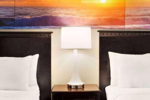 a hotel room with two beds and a lamp on a table at Days Inn by Wyndham Ocean City Oceanfront in Ocean City