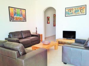 a living room with two couches and a tv at Avalon Villa in Santa Maria