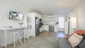 a kitchen and living room with a couch and a counter at Beach Vibes at Terrigal in Terrigal
