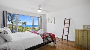 1 dormitorio con 1 cama con escalera y ventana grande en Beach Bay and Bush at Killcare en Killcare