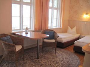 a living room with a table and chairs and a couch at Villa Maria im historischen Bäderstil in Sassnitz