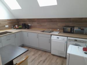 a kitchen with white cabinets and a sink and a microwave at Altes Gesellenhaus in Dinklage