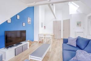 a living room with a blue accent wall and a blue couch at Le Bâle in Strasbourg