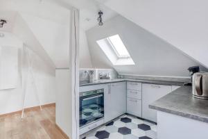 a kitchen with white cabinets and a skylight at Le Bâle in Strasbourg