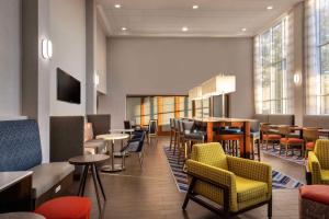 um restaurante com cadeiras e mesas e um bar em Hampton Inn & Suites State College at Williamsburg Square em State College