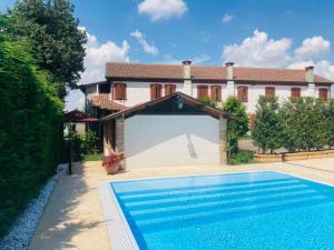 a villa with a swimming pool in front of a house at Corte Bussari in Arquà Polesine