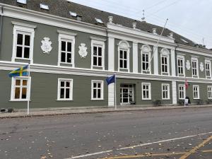 un gran edificio verde al lado de una calle en Hotel Harmonien en Nakskov