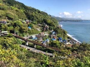 einen Bahnhof auf einem Hügel neben dem Meer in der Unterkunft 伊豆海の家（Izu Seaside Villa） in Higashiizu