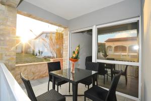 a dining room with a table and chairs on a balcony at Holiday home Tomislav for 12 guests near the beach in Vir