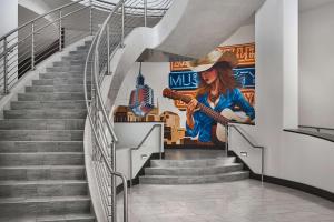 uma escadaria com um mural de uma mulher a tocar guitarra em Hilton Garden Inn Nashville Downtown/Convention Center em Nashville