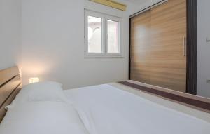 a bedroom with a large bed and a wooden door at Holiday home Tomislav for 12 guests near the beach in Vir