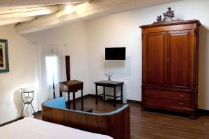 1 dormitorio con 1 cama y armario de madera en Agrirėlais Eremo Sant’Anna, en Valverde