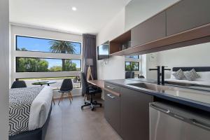 a bedroom with a bed and a kitchen with a sink at Quality Hotel Mildura Grand in Mildura