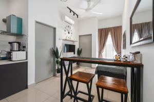 cocina con mesa y 2 sillas en una habitación en Gombak Homestay at Ayuman Suites Kuala Lumpur, en Kampong Kerdas