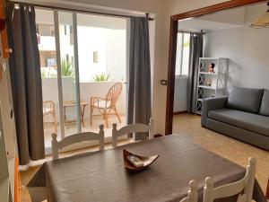 sala de estar con mesa y sofá en Apartments Yes, Es Pujols-Formentera vacaciones, en Es Pujols