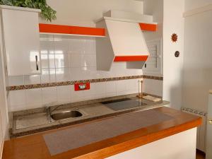 una cocina con armarios blancos y fregadero en Apartments Yes, Es Pujols-Formentera vacaciones, en Es Pujols