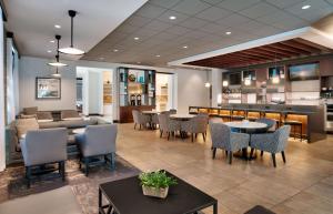 a restaurant with tables and chairs and a bar at Hyatt Place Provo in Provo