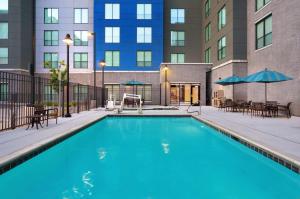 a swimming pool with tables and chairs and a building at Hyatt Place Provo in Provo