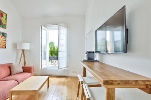 a living room with a table and a couch at Charmant appartement à 10 minutes de la Défense in Suresnes