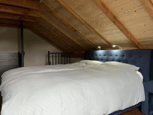 una camera da letto con un grande letto bianco con testiera blu di Brour&Bos a Laren
