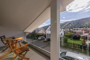 a balcony with a wooden chair and a view of a street at Ski Apartments Frigo Pohorje 1 and 2 - Happy Rentals in Maribor