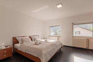 a bedroom with a large bed and two windows at Ski Apartments Frigo Pohorje 1 and 2 - Happy Rentals in Maribor
