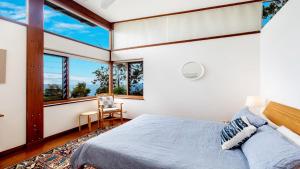 a bedroom with a bed and large windows at Atlas Beach House in Killcare +16 photos