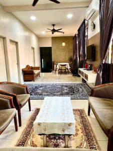a living room with a table and a dining room at Rumah Mok Aji Homestay Melaka in Melaka