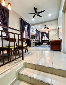 Rumah Mok Aji Homestay Melaka في ميلاكا: غرفة معيشة مع مروحة سقف وأريكة