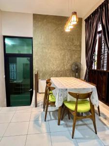 uma sala de jantar com uma mesa e duas cadeiras em Rumah Mok Aji Homestay Melaka em Malaca