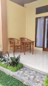 a patio with two benches and a table at D'Natha Villa Ubud in Ubud