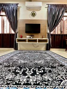 a living room with a black and white rug at Rumah Mok Aji Homestay Melaka in Melaka