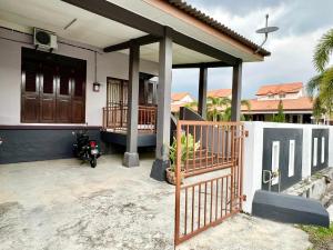 a house with a motorcycle parked in front of it at Rumah Mok Aji Homestay Melaka in Melaka