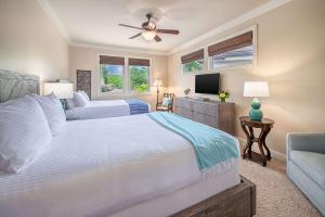 a bedroom with two beds and a flat screen tv at Ho Olei Residences - CoralTree Residence Collection in Wailea