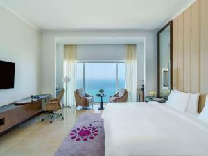 a hotel room with a large bed and a view of the ocean at Rixos Marina Abu Dhabi in Abu Dhabi