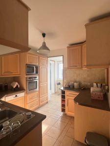 a kitchen with wooden cabinets and a black counter top at Courbevoie Riverview in Courbevoie