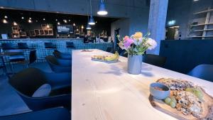 a long table with a vase of flowers and bread at Story Thusis in Thusis