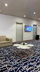 a room with a couch and a table and a tv at أستراحة مون لايت الريفي in AlUla