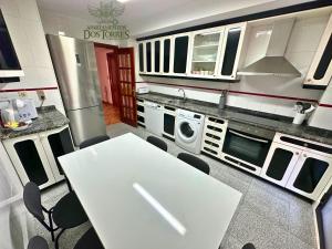 a kitchen with a white table and some appliances at Dos Torres Gómez Laguna - Estacionamiento Privado Gratuito in Zaragoza