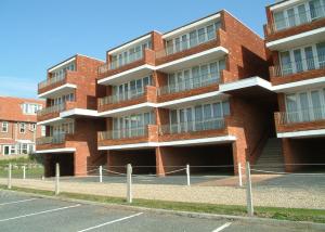 10 Vista Court في شيرينغهام: مبنى من الطوب الأحمر مع موقف للسيارات أمامه