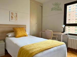 a bedroom with a bed with a yellow blanket on it at Dos Torres Gómez Laguna - Estacionamiento Privado Gratuito in Zaragoza