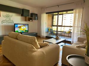 a living room with two couches and a tv at Dos Torres Melkor - in Zaragoza