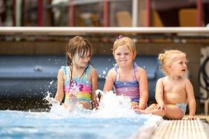 three girls sitting in the water in a pool at H2O-Hoteltherme in Bad Waltersdorf