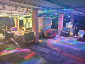 een kamer met een podium met kleurrijke verlichting en stoelen bij Palmquist Villa in Neral