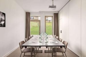 Vienna House by Wyndham MQ Kronberg في كرونبرج إم تانوس: قاعة المؤتمرات مع طاولة وكراسي طويلة