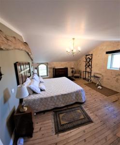 een slaapkamer met een bed en een kroonluchter bij La Chartreuse d'Ertan "Les vignerons" 4 étoiles in Saint-Christophe-des-Bardes