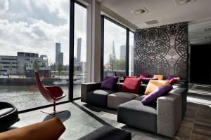 uma sala de estar com um sofá e uma grande janela em Mainport Hotel Rotterdam em Roterdã