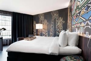 een hotelkamer met een groot bed en een bank bij Mainport Hotel Rotterdam in Rotterdam