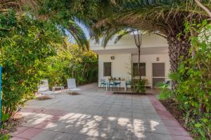 un jardín con patio y una casa con árboles en Villa Nami a 50mt dalla spiaggia, en Torre Santa Sabina