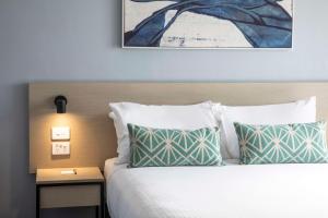 Nightcap at Rex Hotel في أديلايد: غرفة نوم مع سرير مع وسادتين